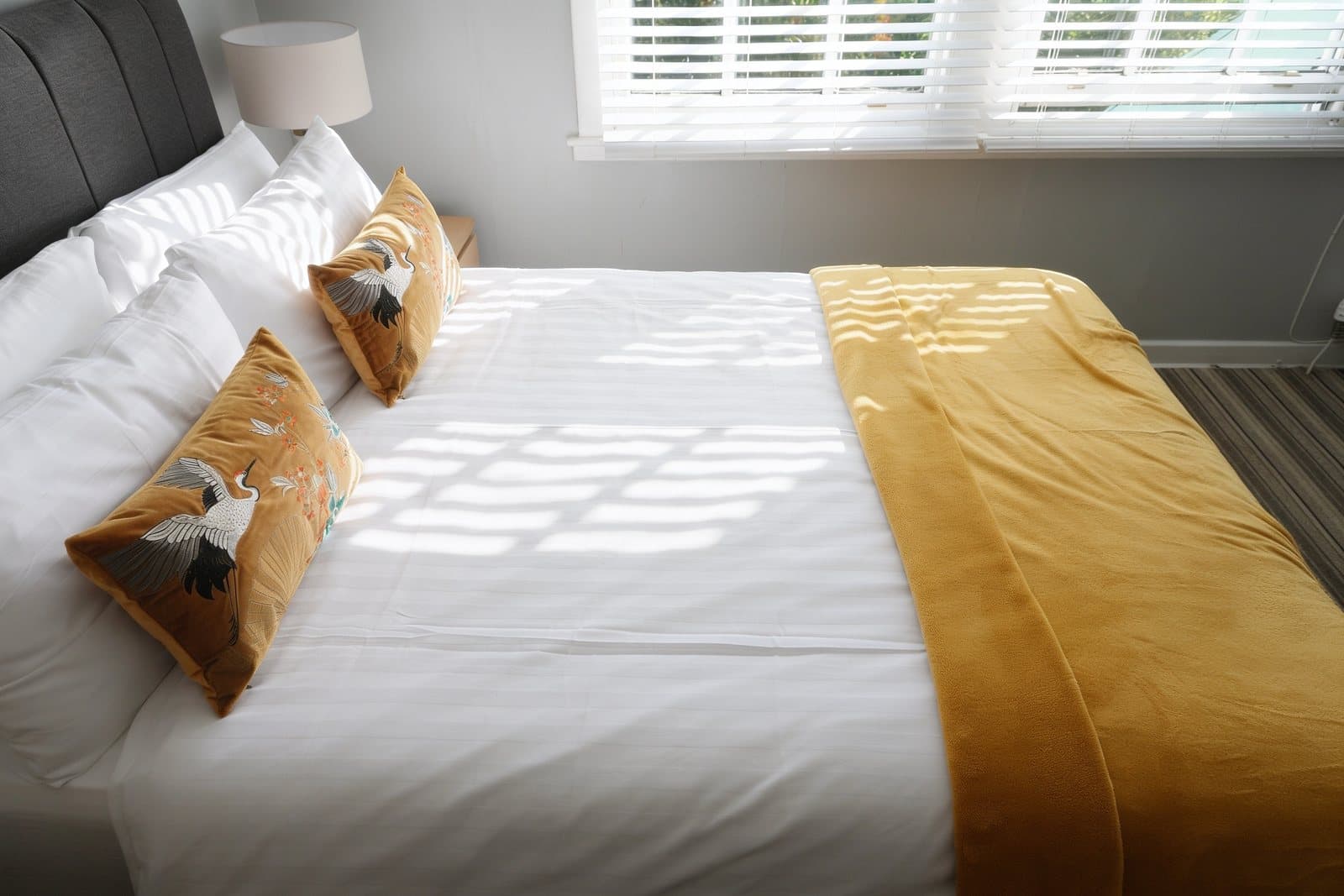 The finished photo: the double bed with sunlight falling across it through the shutters