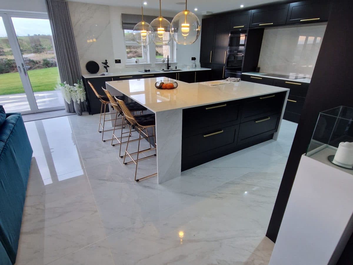 An open-plan kitchen and dining space with a large-format polished porcelain floor