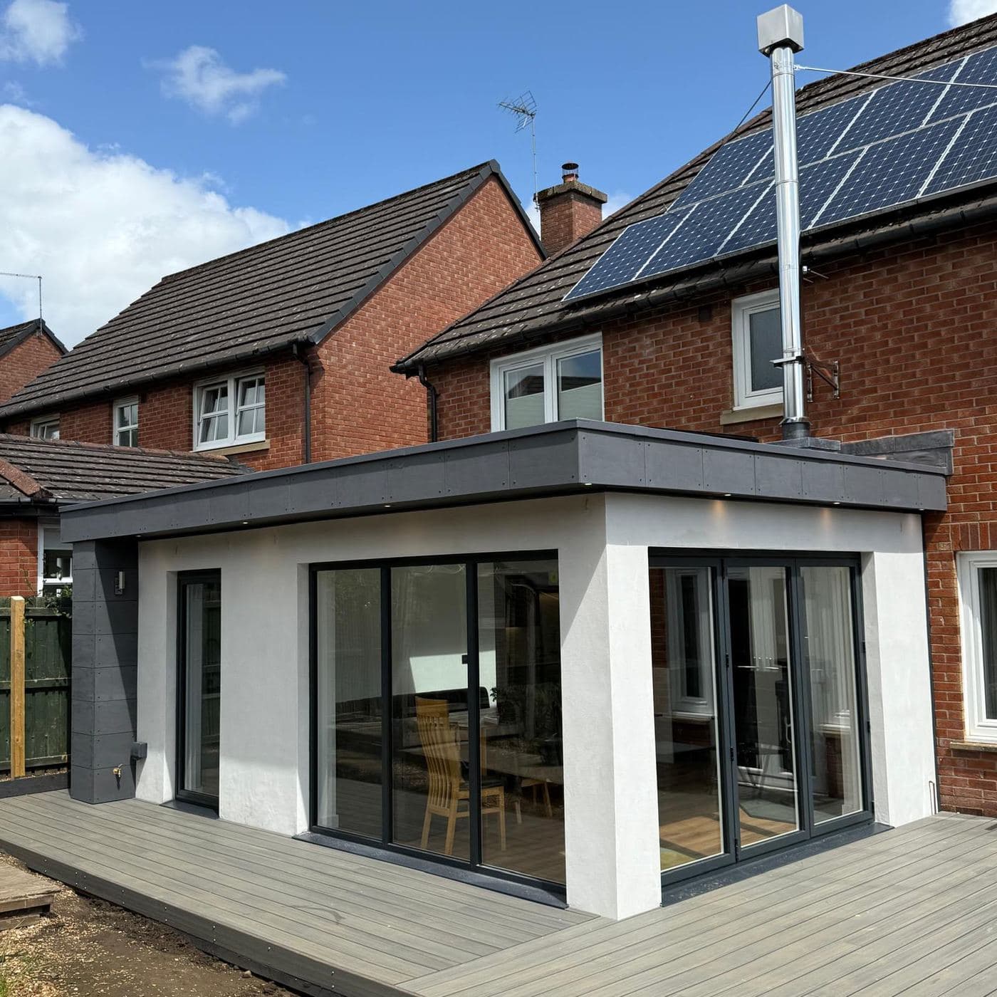 A finished single-storey rear extension with grey bifold doors and a composite deck